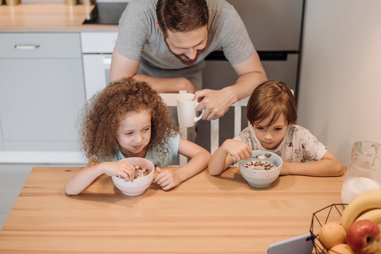 Father and children enjoying a hearty breakfast at home, creating a warm family moment.